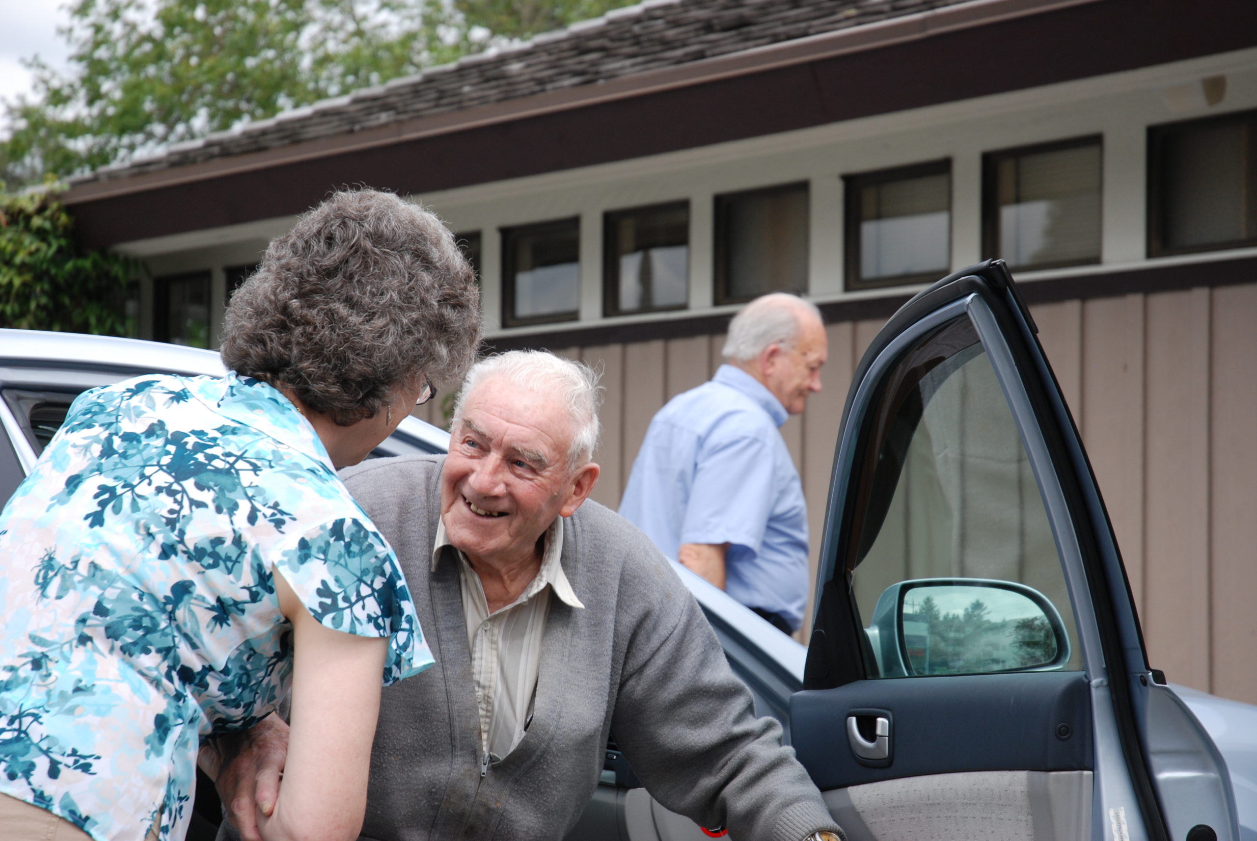 Senior Better at Home Client getting help out of a car.